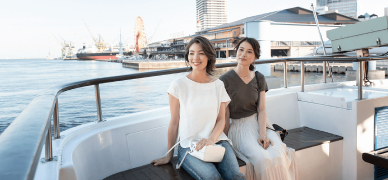 写真：神戸港の海で遊覧船に乗る二人の女性
